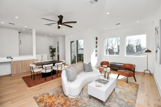 living area with recessed lighting, light wood-style floors, and visible vents