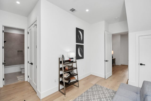 interior space with baseboards, light wood-style floors, visible vents, and recessed lighting
