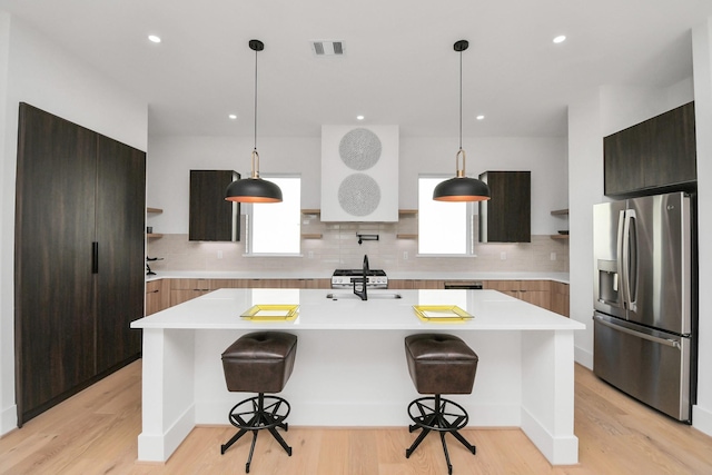 kitchen featuring visible vents, modern cabinets, open shelves, stainless steel refrigerator with ice dispenser, and light countertops