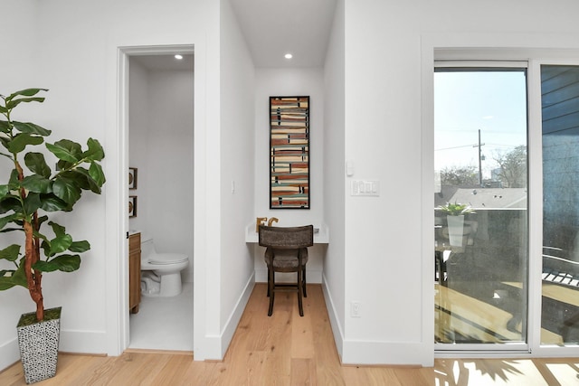 hallway featuring recessed lighting, baseboards, and light wood-type flooring