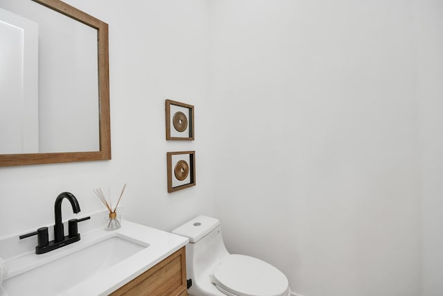half bath featuring toilet and vanity