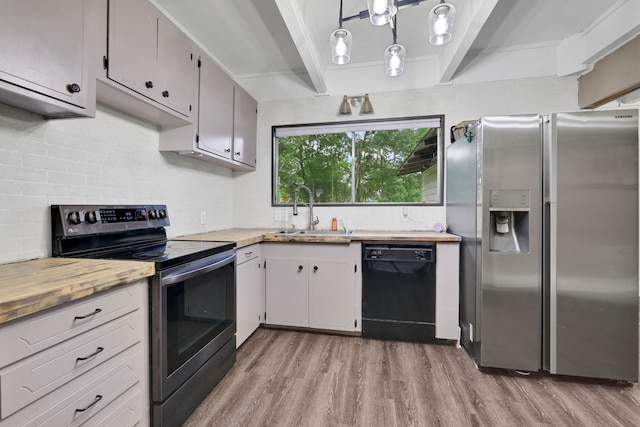 kitchen with a sink, appliances with stainless steel finishes, tasteful backsplash, and wood finished floors