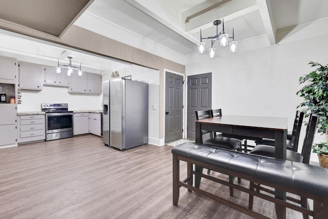 kitchen featuring beamed ceiling, light wood-type flooring, light countertops, appliances with stainless steel finishes, and a notable chandelier