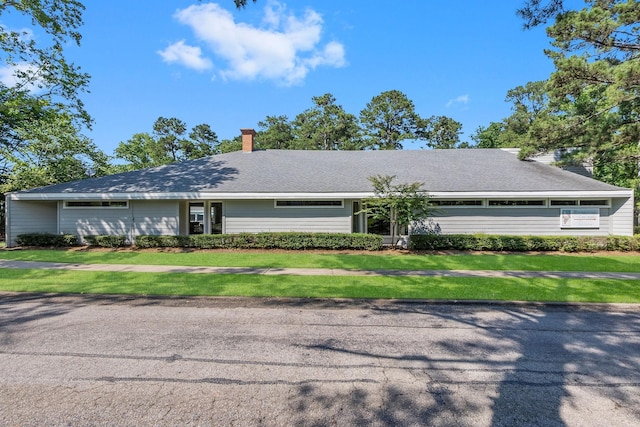 ranch-style home with a front lawn and a chimney