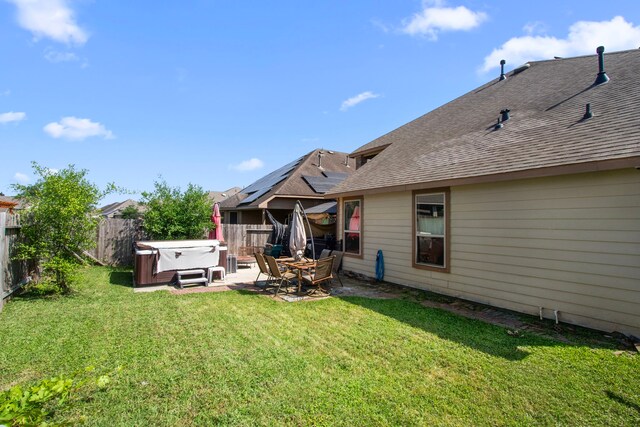 13207 Davenport Hills Ln, Humble, TX 77346 - back of property with a fenced backyard, a shingled roof, a patio area, a lawn, and a hot tub