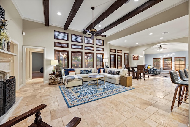 living room featuring stone tile floors, ceiling fan, arched walkways, a fireplace, and recessed lighting