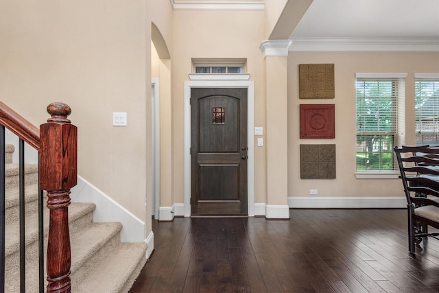 entryway with stairway, dark wood-style floors, arched walkways, crown molding, and baseboards