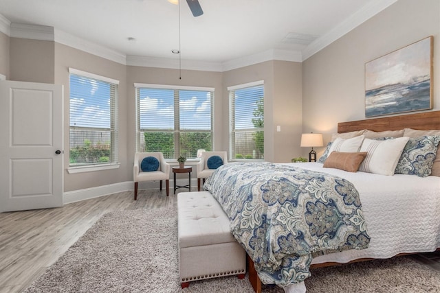 bedroom featuring wood finished floors, ornamental molding, and multiple windows