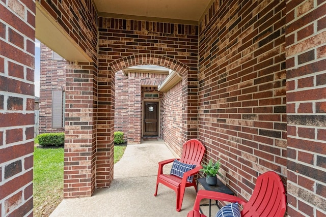 view of exterior entry featuring brick siding