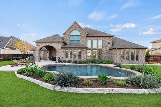 view of swimming pool featuring fence, a lawn, a fenced in pool, and a patio