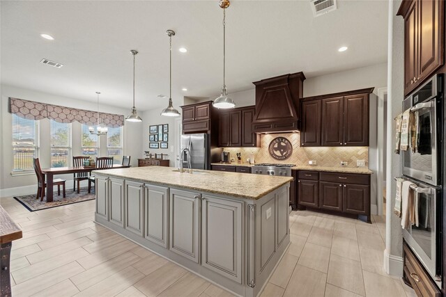 kitchen with premium range hood, tasteful backsplash, visible vents, and appliances with stainless steel finishes