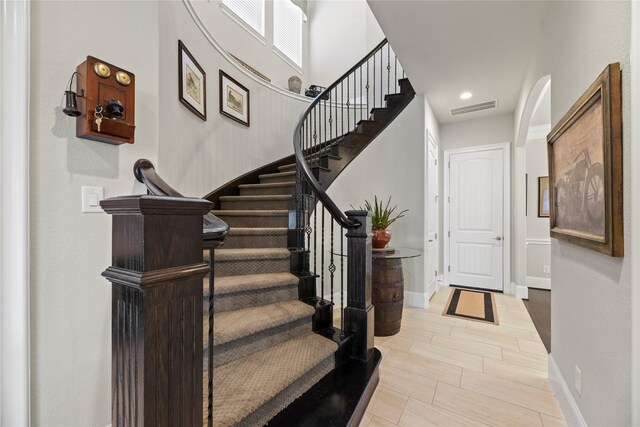 staircase featuring baseboards and visible vents