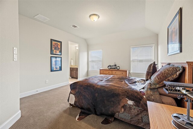 bedroom with ensuite bath, light carpet, baseboards, and visible vents