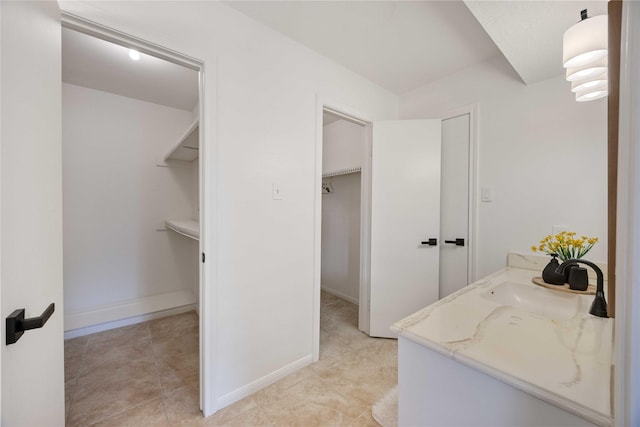 bathroom with baseboards, vanity, and tile patterned floors