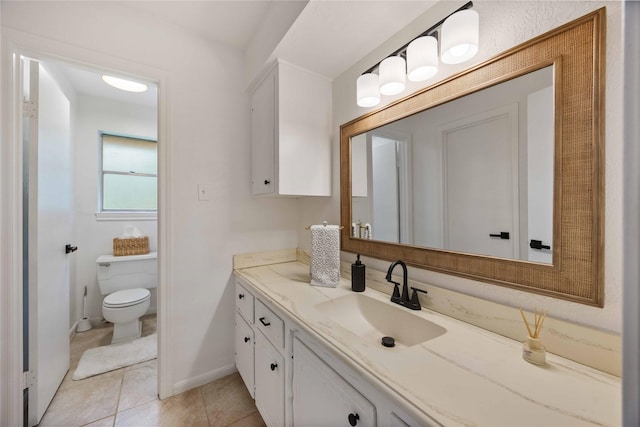 bathroom featuring baseboards, toilet, vanity, and tile patterned floors