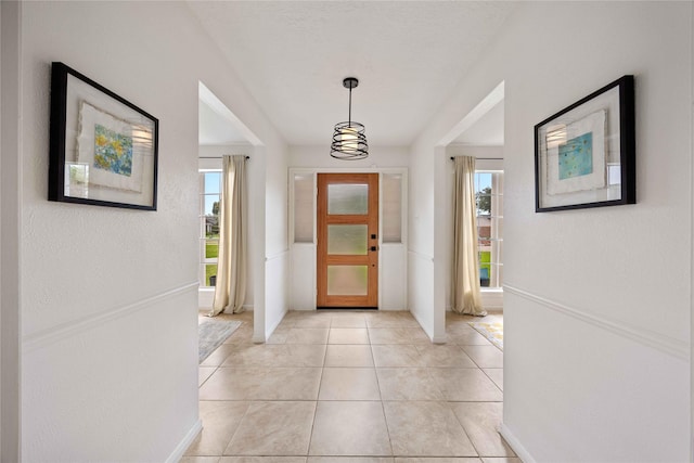 foyer with baseboards and light tile patterned flooring