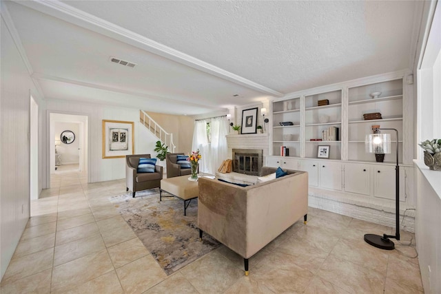 living area with visible vents, light tile patterned floors, a fireplace, a textured ceiling, and stairs