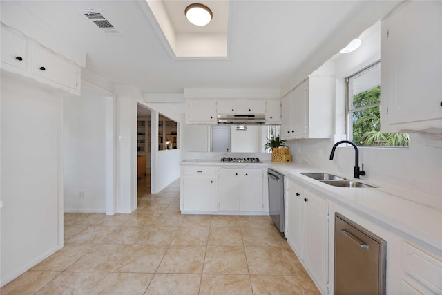 kitchen with under cabinet range hood, dishwasher, visible vents, gas cooktop, and a sink