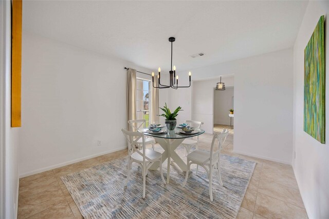 dining space with visible vents, baseboards, a notable chandelier, and light tile patterned floors