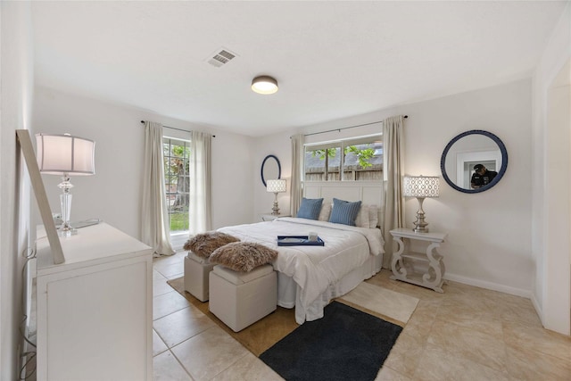 bedroom with multiple windows, visible vents, and light tile patterned floors