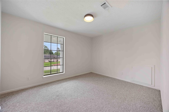 empty room featuring baseboards, visible vents, and carpet
