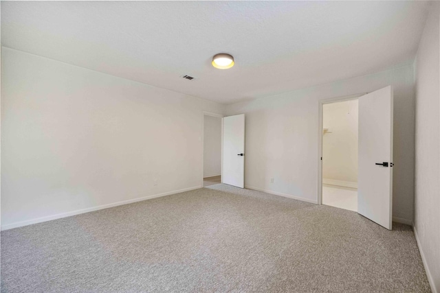spare room with visible vents, carpet flooring, and baseboards