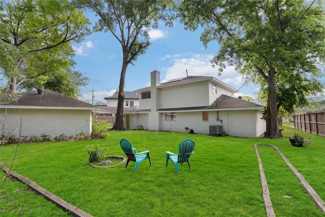 view of yard featuring fence and central AC