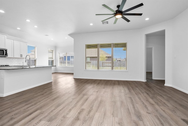 31411 Raleigh Creek Dr, Tomball, TX 77375 - unfurnished living room with a sink, recessed lighting, plenty of natural light, a ceiling fan, and wood finished floors
