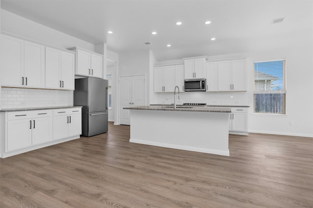 31411 Raleigh Creek Dr, Tomball, TX 77375 - kitchen featuring stainless steel appliances, a sink, tasteful backsplash, white cabinetry, and recessed lighting