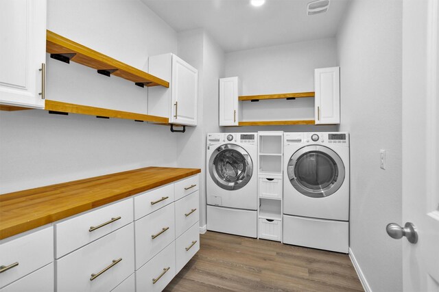31411 Raleigh Creek Dr, Tomball, TX 77375 - laundry area featuring washing machine and dryer, cabinet space, dark wood-type flooring, and baseboards