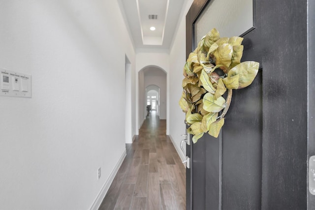 corridor featuring visible vents, baseboards, arched walkways, recessed lighting, and wood finished floors