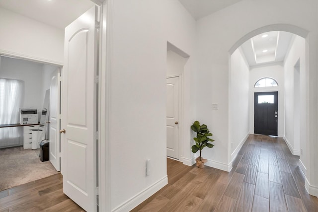 foyer entrance with baseboards, recessed lighting, arched walkways, and wood finished floors