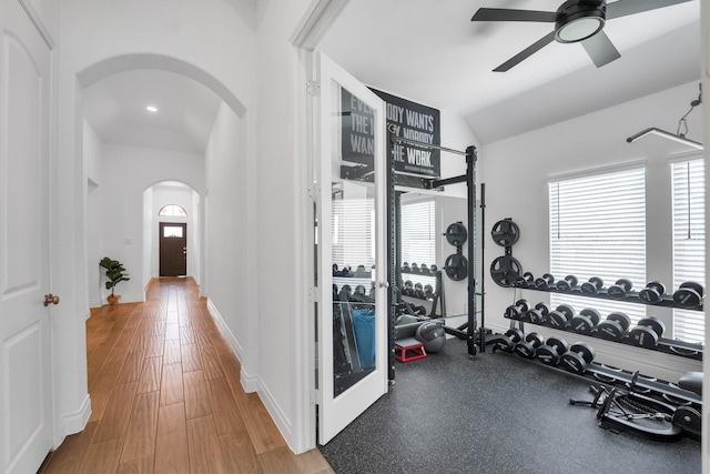 interior space with arched walkways, a wealth of natural light, wood finished floors, and lofted ceiling