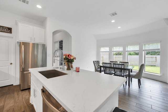 20131 Wild Horse Hollow Ln, Tomball, TX 77377 - kitchen featuring appliances with stainless steel finishes, a sink, arched walkways, white cabinetry, and recessed lighting