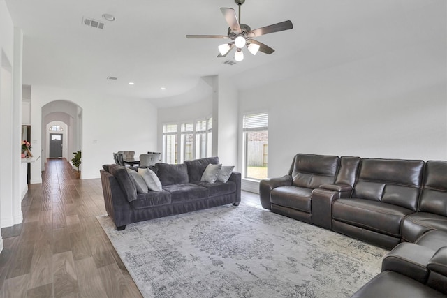 living area featuring recessed lighting, a ceiling fan, visible vents, arched walkways, and wood finished floors