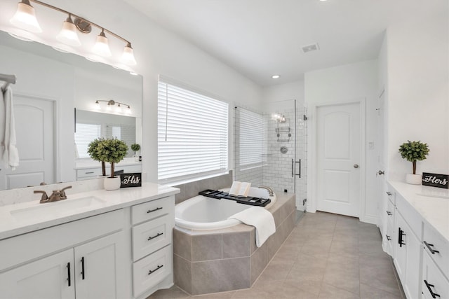 bathroom featuring tile patterned flooring, two vanities, a shower stall, a bath, and a sink