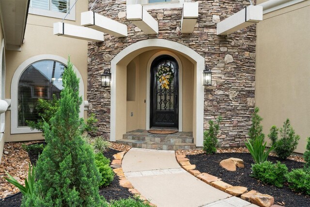 entrance to property with stone siding and stucco siding