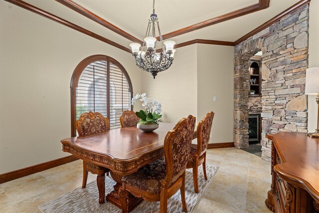 dining area featuring baseboards, a chandelier, ornamental molding, and a raised ceiling