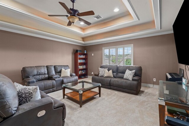 living area featuring visible vents, baseboards, light colored carpet, a raised ceiling, and a ceiling fan