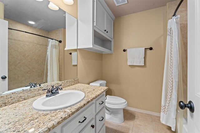 bathroom featuring vanity, toilet, tile patterned floors, baseboards, and visible vents