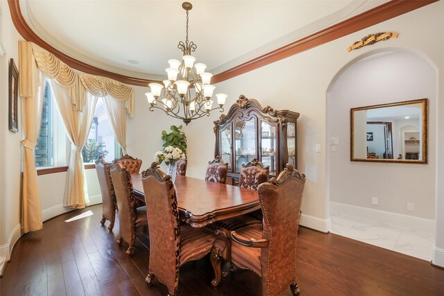 dining room featuring arched walkways, a notable chandelier, crown molding, and baseboards