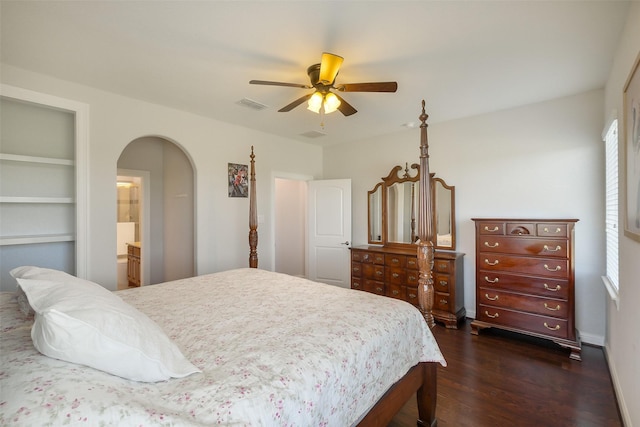 bedroom with arched walkways, ceiling fan, visible vents, and dark wood-style flooring