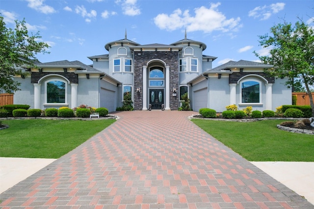 view of front facade featuring stucco siding, decorative driveway, and a garage
