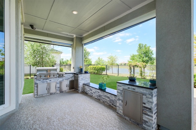 view of patio / terrace with area for grilling, a fenced backyard, and exterior kitchen