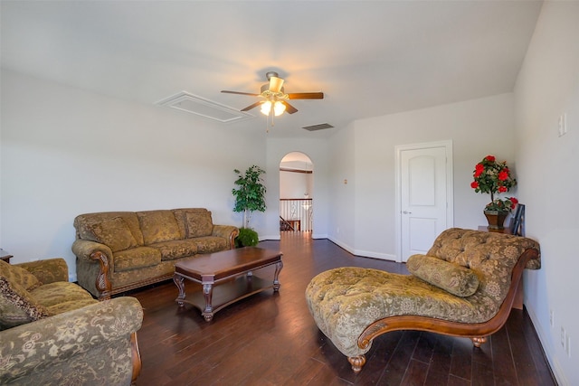 living room featuring wood finished floors, visible vents, arched walkways, attic access, and ceiling fan