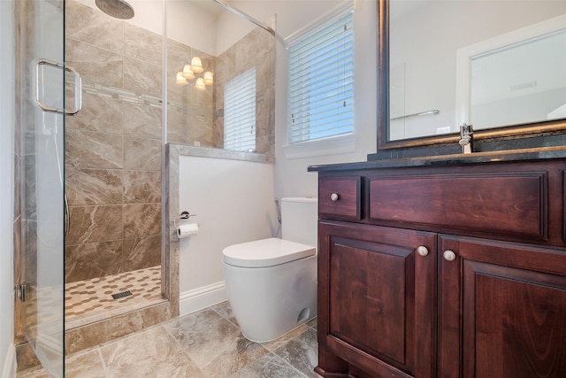 bathroom featuring vanity, a shower stall, and toilet