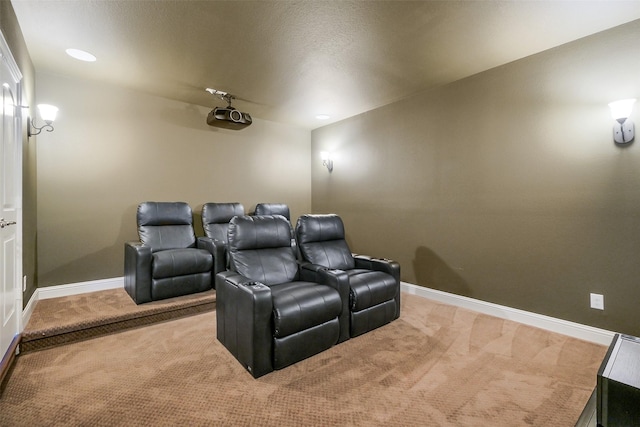 carpeted home theater room with a textured ceiling and baseboards