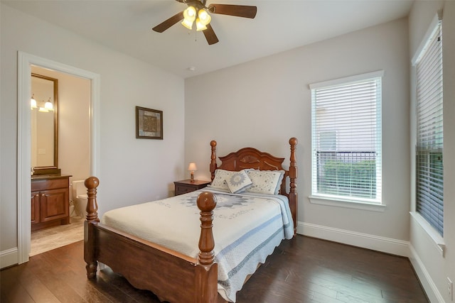 bedroom with ensuite bathroom, baseboards, dark wood-type flooring, and ceiling fan