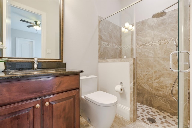 bathroom with vanity, a ceiling fan, a stall shower, and toilet