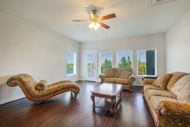 living room with dark wood-type flooring, visible vents, a ceiling fan, and baseboards